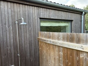 A wooden structure with a metal shower head and a window with a curtain. - "Pirka" - 500m from the sea by Interhome (Væggerløse)