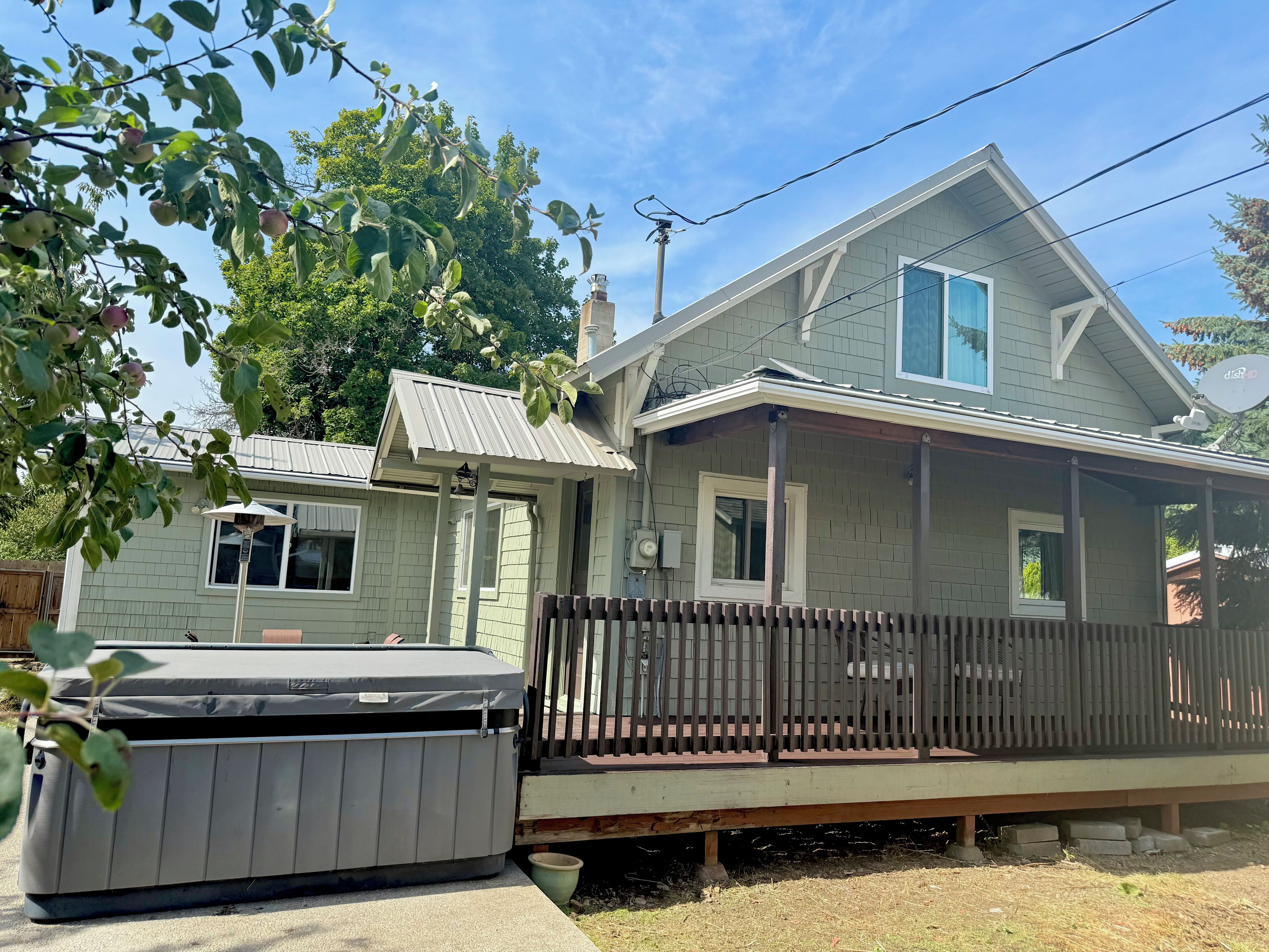 A two-story house with a porch, a covered patio, and a small shed.