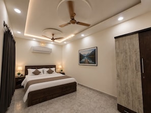 A bedroom with a bed, a ceiling fan, recessed lighting, an air conditioning unit, a nightstand with a lamp, a framed picture on the wall, and a wardrobe. - Spacious 4-bedroom house in peaceful Kandwa with AC (Kandwa)