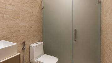 A modern bathroom with a toilet, bidet, and shower area.
