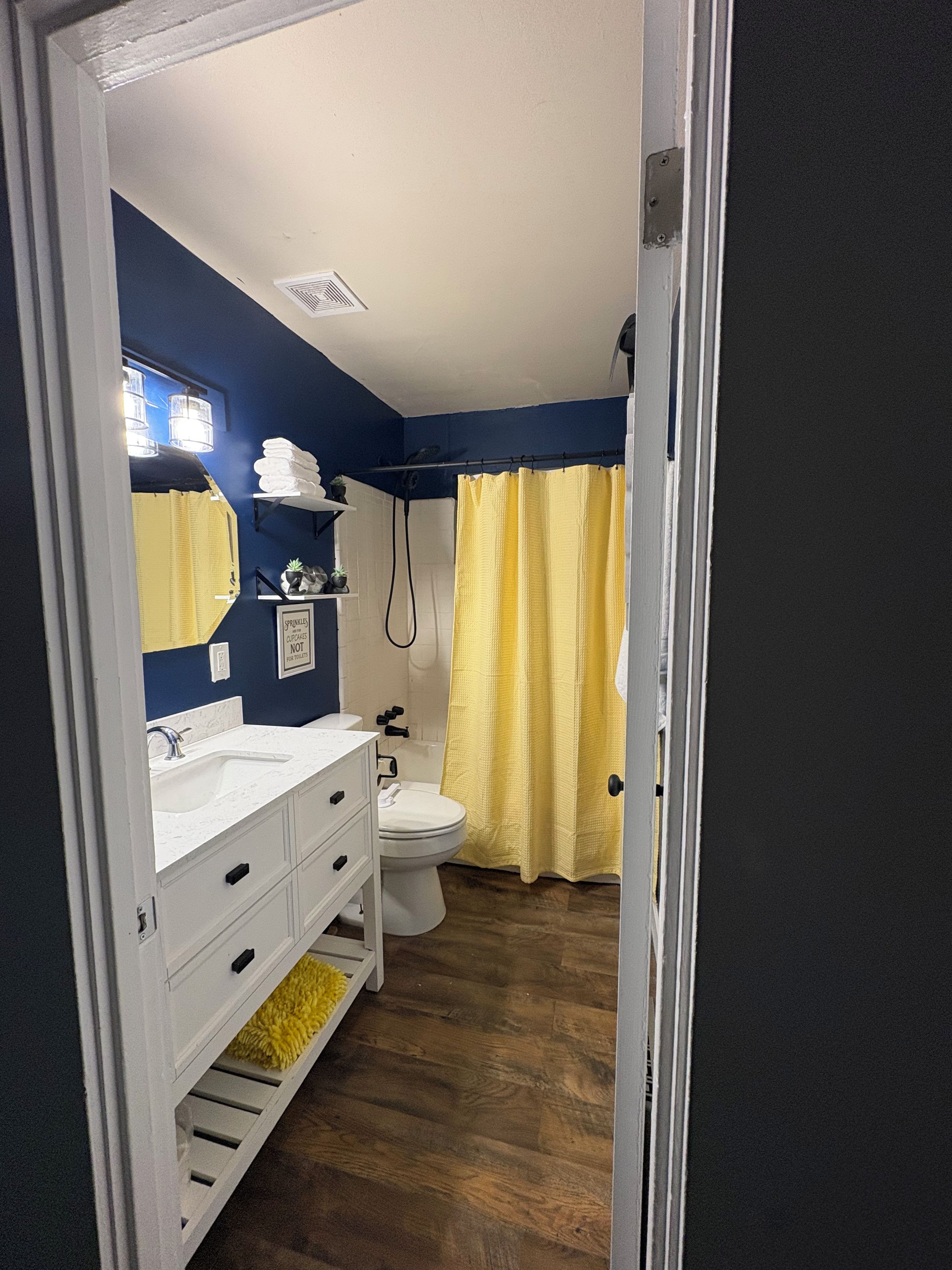 Un baño con lavamanos blanco, inodoro y cortina de ducha.