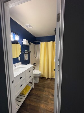A bathroom with a white sink, a toilet, and a shower curtain. - Find comfort and relaxation when experiencing your vacation (Twin Falls)