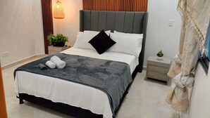 Un dormitorio moderno con cama, mesitas de noche, una lámpara colgante y un panel de pared de madera.