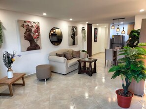 A modern living room with a sofa, coffee table, and a potted plant. - Exclusive, luxurious, centrally located apartment — serene and comfortable 302 (Medellín)