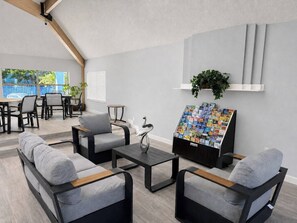A modern lounge area with sofas, a coffee table, and a magazine rack. - 3BR Steps from Clubhouse Near Disney (Kissimmee)