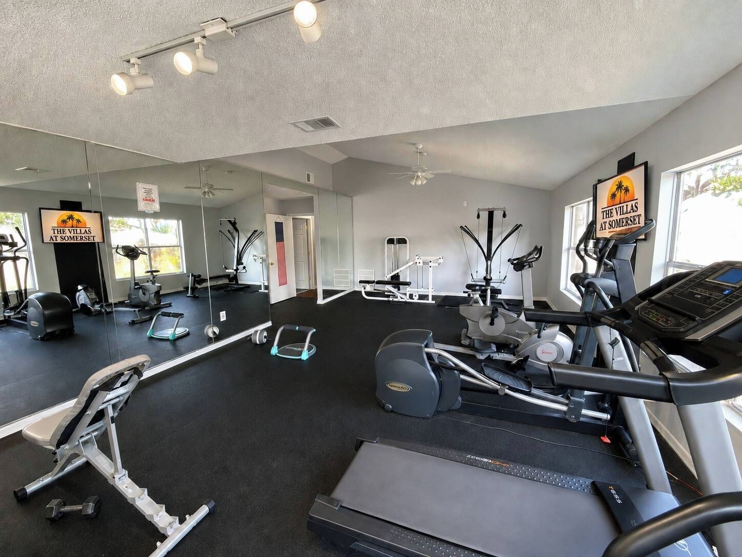 A gym with treadmills, elliptical machines, and free weights.