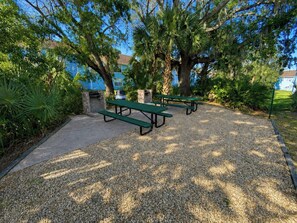 An outdoor seating area with picnic tables and a barbecue grill. - 3BR Steps from Clubhouse Near Disney (Kissimmee)