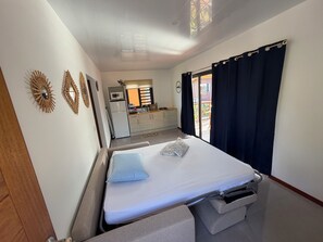 Ein Hotelzimmer mit Bett, einer Küchenzeile und Blick ins Freie.