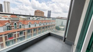 Un balcó amb vista a edificis tradicionals i un gratacels modern.