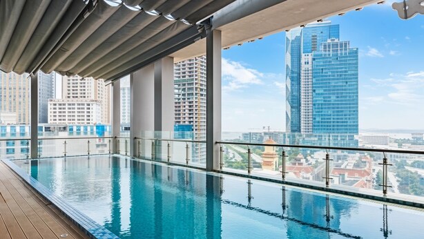 Una piscina d'hidromassatge infinit a la terrassa amb vista a edificis alts.
