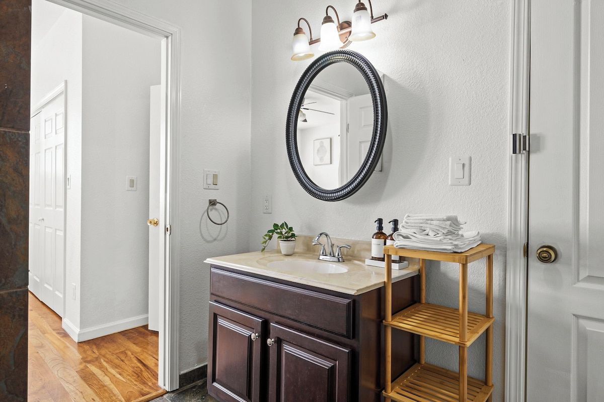 Une salle de bain avec un meuble-lavabo, un miroir et une étagère.