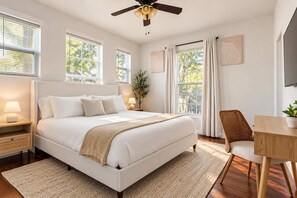 A bedroom with a large bed, bedside tables, a ceiling fan, and a view of the outdoors. - Central Austin Luxury - Hot Tub - Game Room - Private Gate (Austin)