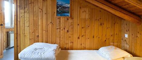 Una habitación con paneles de madera, una cama y un sillón.
