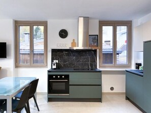 A modern kitchen with a built-in oven, a marble backsplash, and a window with a view of the outside. - AffittiPontediLegno - Panorama 3B (Temù)