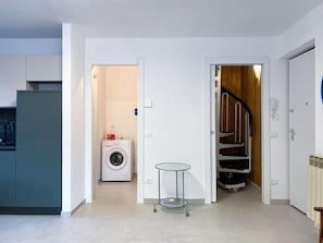 A modern kitchen with a washing machine and a small table in a hallway. - AffittiPontediLegno - Panorama 3B (Temù)