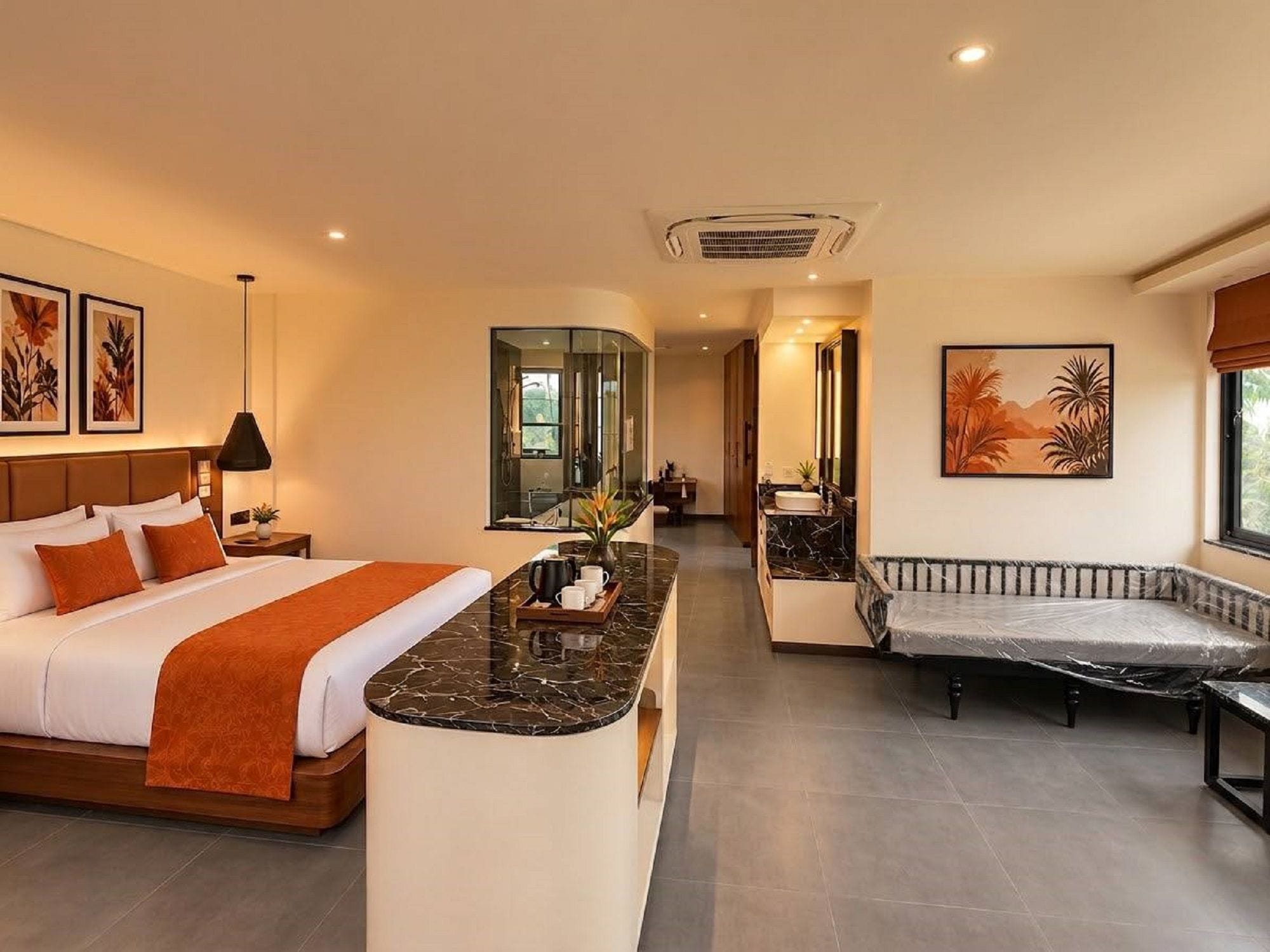 A hotel room with a bed, a sitting area, a bathroom, and a view of the outdoors.
