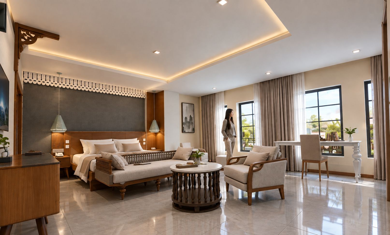 Ein modernes Hotelzimmer mit Bett, Sofa, Sessel, rundem Couchtisch und Schreibtisch mit Stuhl.