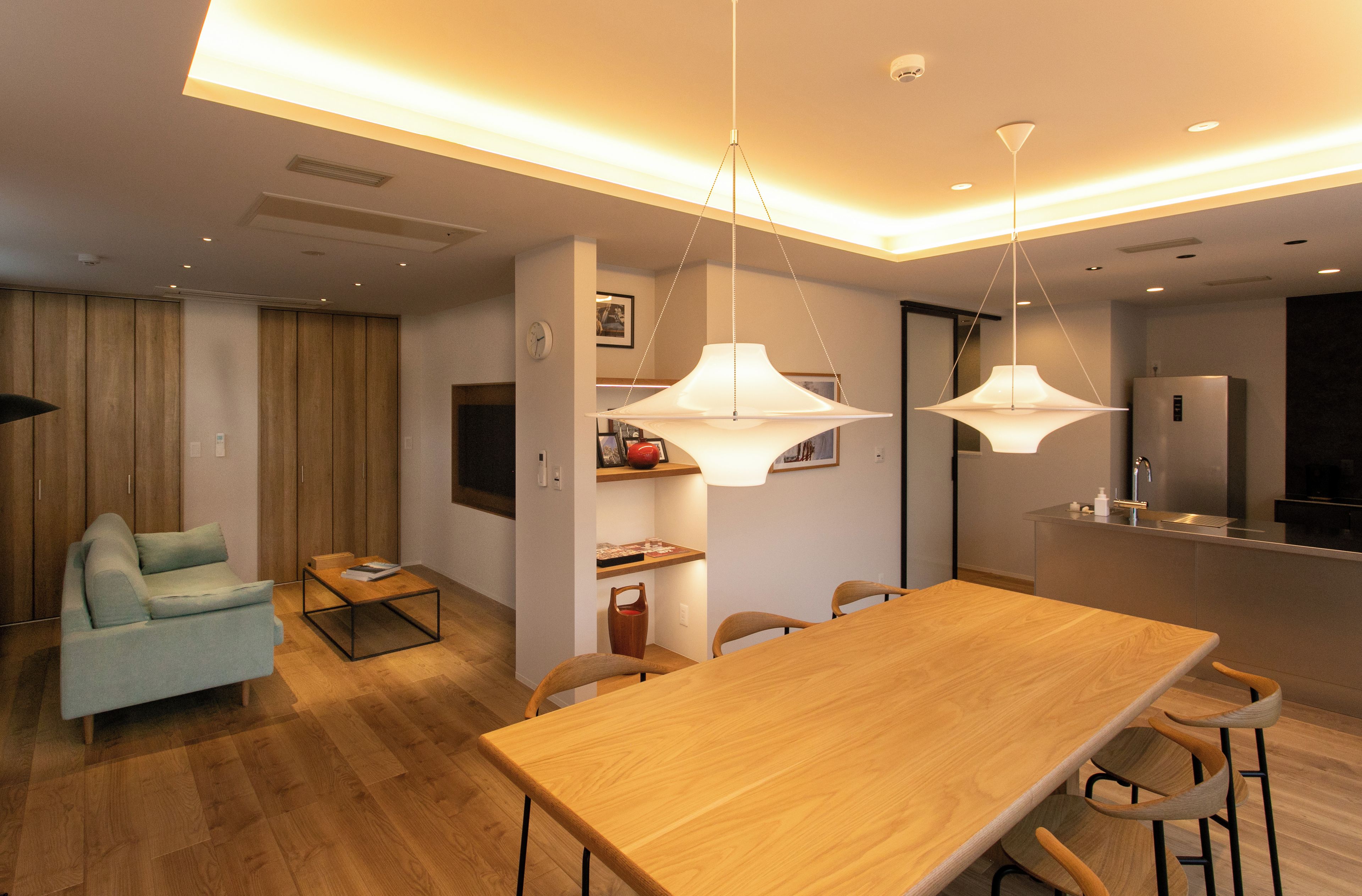 A modern living space with a dining area, kitchen, and a seating area with a sofa and coffee table.