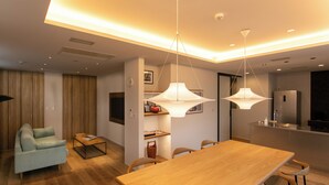 Un espacio moderno para vivir con comedor, cocina y zona de estar con sofá y mesa de centro.