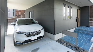 Un edificio moderno con un coche blanco estacionado frente a él.
