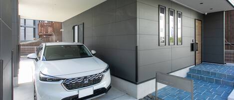 A modern building with a white car parked in front.