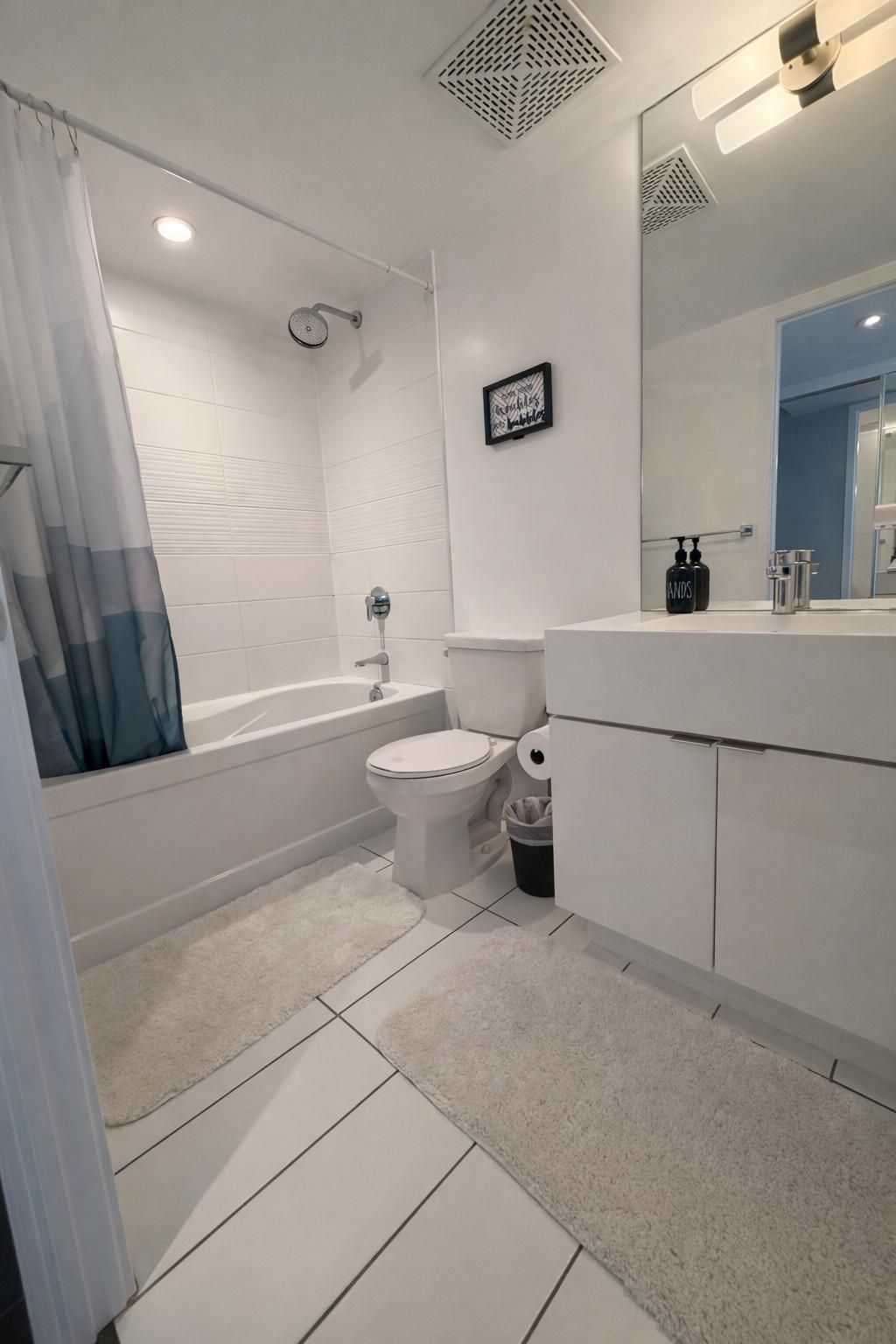 A modern bathroom with a bathtub, toilet, and sink.