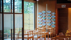 Une pièce meublée en bois, dont un mur est décoré d’éventails traditionnels.