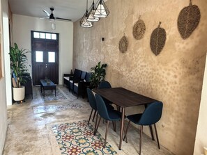 A dining area with a table and chairs, a patterned rug, and wall decor. - House 54, Mérida (Mérida)