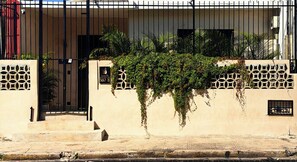 A building with a gated entrance, a sign indicating 'Casa 54,' and a wall with a geometric pattern. - House 54, Mérida (Mérida)