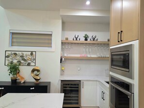 A modern kitchen with built-in appliances, a countertop, and a decorative wall piece.