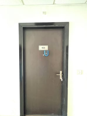 Eine Tür mit einem Nummernschild mit der Aufschrift '421' und einem Schlüsselloch.