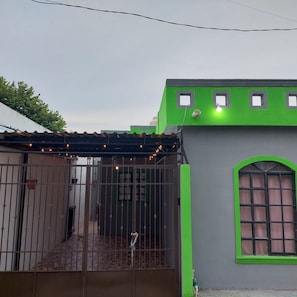 A building with a green facade, a gated entrance, and a covered patio area. - Casa Ju (Pet-Friendly) (Ciudad Valles)