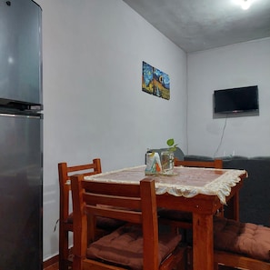 A dining area with a wooden table, chairs, and a refrigerator. - Casa Ju (Pet-Friendly) (Ciudad Valles)
