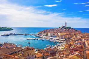 A coastal town with a prominent tower, a marina with boats, and historic buildings. - Residence Skiper Savudrija Apt 153 Pool & Gym, Savudrija, Croatia (Savudrija)