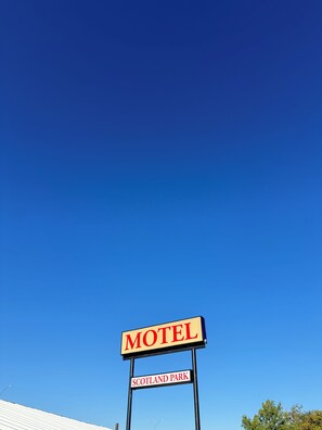 Señal de motel con la palabra 'MOTEL' y 'SCOTLAND PARK' escritas.