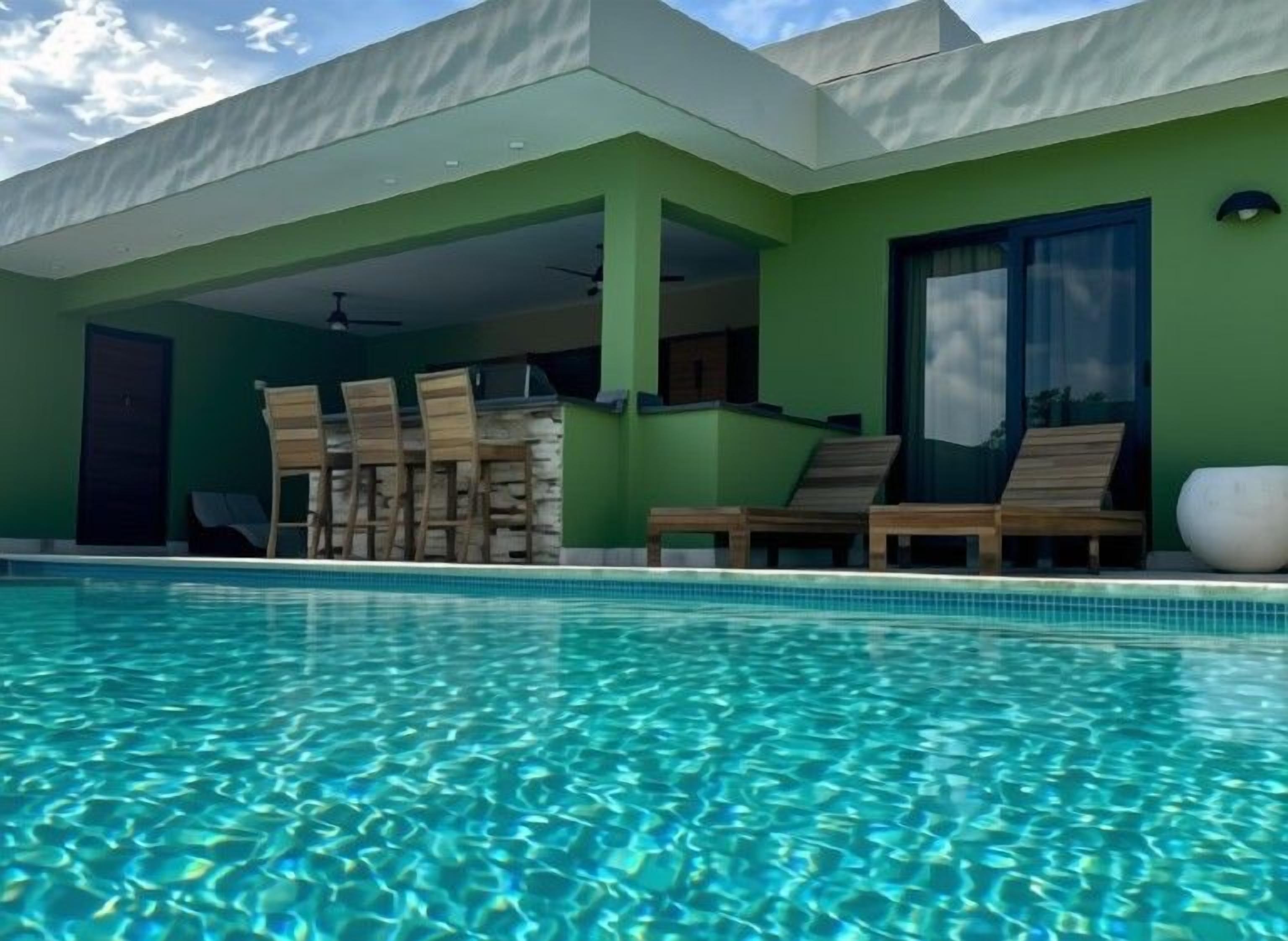 A swimming pool with lounge chairs and a covered patio area.