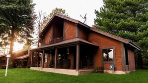 A two-story wooden house with a covered porch and a satellite dish. - 5-BR Family Retreat – Pool Table & Waffles (Provo)