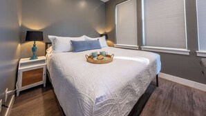 Ein Schlafzimmer mit einem großen Bett, einem Nachttisch mit Lampe und einem Tablett mit Frühstücksangeboten.