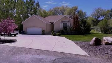 A residential house with a garage, driveway, and surrounding trees.