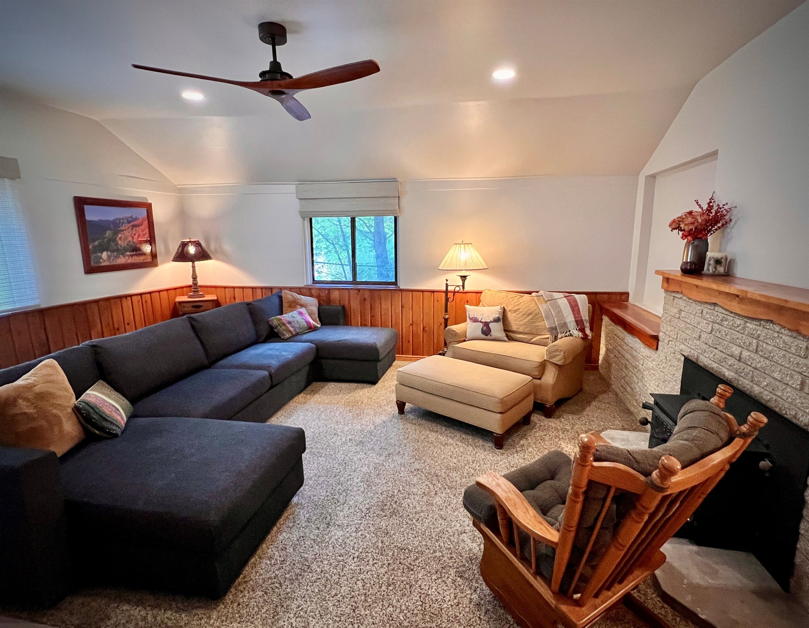 Living room with a sectional and stone fireplace