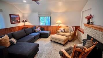 Living room with a sectional and stone fireplace