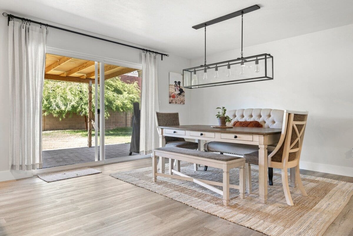 Cocina moderna con mesa de comedor de madera, banco y lámpara colgante.