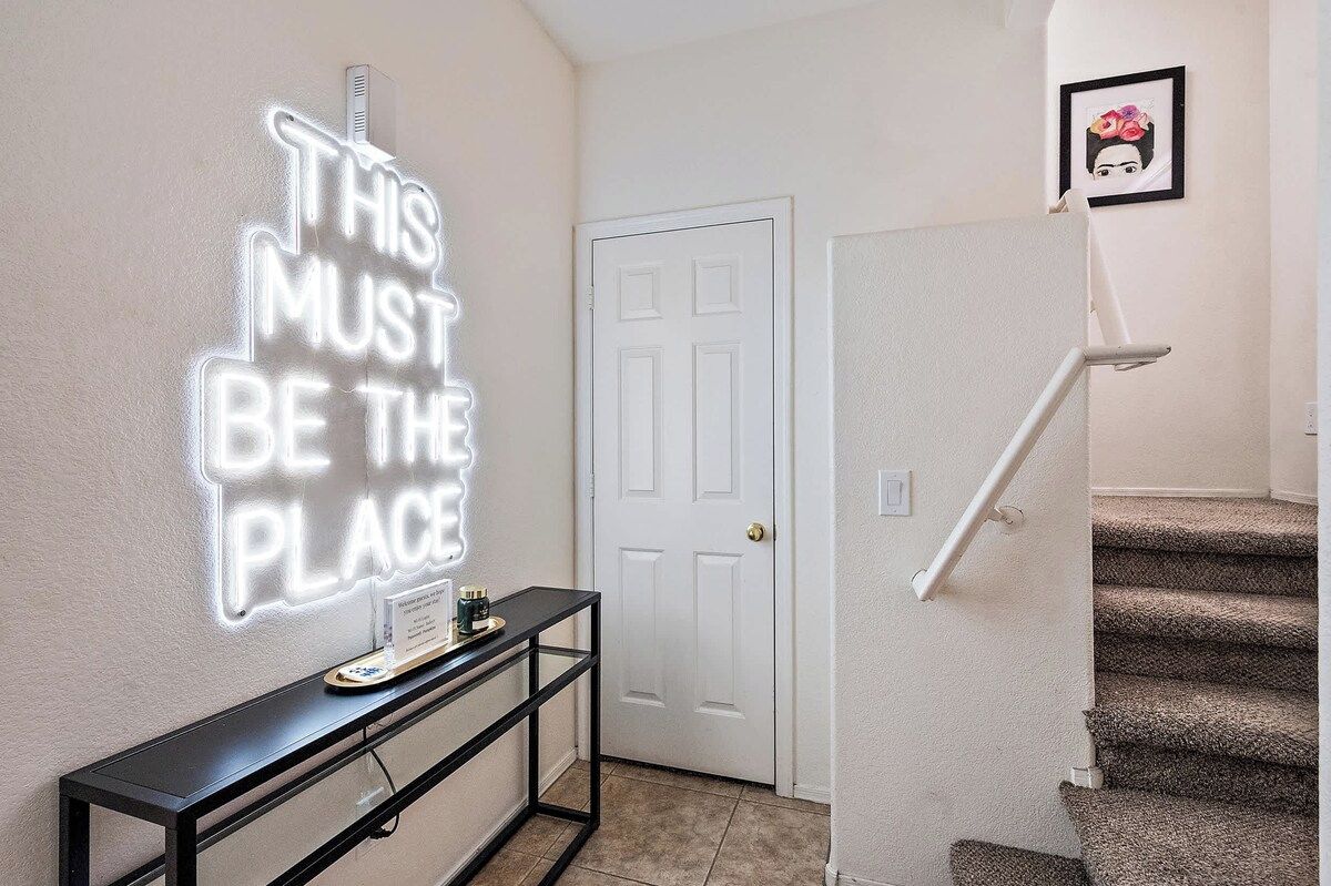 A staircase with a handrail, a wall-mounted sign, and a door.