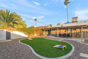 A backyard with artificial grass, a patio area, and a covered seating space. - Scottsdale Monterosa 🌵⛳ Private Pool, Putting Green Near Old Town Scottsdale (Scottsdale)