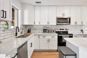 A modern kitchen with white cabinets, a microwave, a toaster, and a dishwasher. - Scottsdale Andora Retreat 🌵⛳ Heated Saltwater Pool Near Kierland Commons (Phoenix)