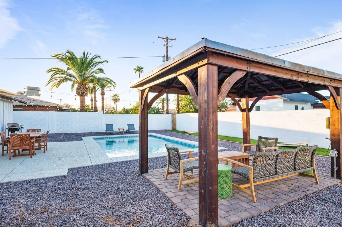 A covered outdoor area with a pool, seating, and a pergola structure.