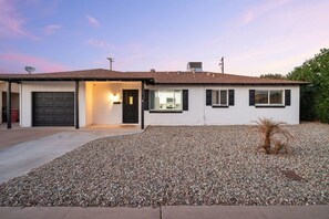 A single-story house with a garage, a front porch, and a gravel driveway. - Old Town Fiesta 🌵⛳ Heated Pool, Game Room Across from Golf in Scottsdale (Scottsdale)