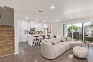 A modern kitchen with white cabinets, a central island, and pendant lighting. - Chandler Townhome 1 🌵 Walk to Downtown Chandler, Community Pool & Grill (Chandler)