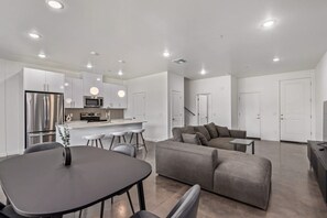 Un espace de vie moderne comprenant un coin repas, une cuisine et un coin salon.