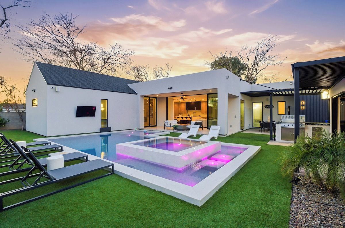 A modern house with a swimming pool, outdoor seating, and a barbecue area.